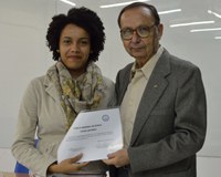 A foto apresenta a discente Kaline Nascimento da Silva, junto a professora Julio Zukerman Schpector, ambos segurando o certificado do prêmio CRQ.
